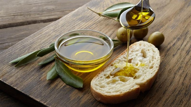 Slices of rustic bread on a plate with a small bowl of olive oil for dipping